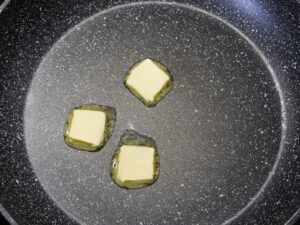 Butter in Pfanne für Spiegeleier schmelzen