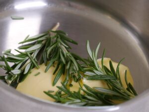 Butter mit Rosmarin für Brathähnchen schmelzen lassen