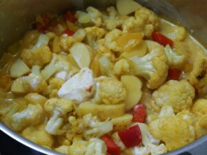 Curry mit Kokosmilch auffüllen und köcheln lassen