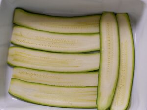 Doppelte Schicht Zucchini-Scheiben in Auflaufform legen