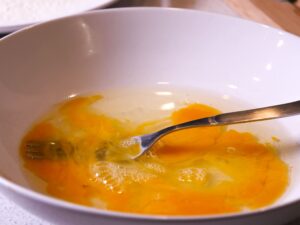 Ei aufschlagen damit Schnitzel Panade anheftet