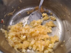 Glasige Zwiebeln mit Mehl bestäuben für Erbsen Rezept
