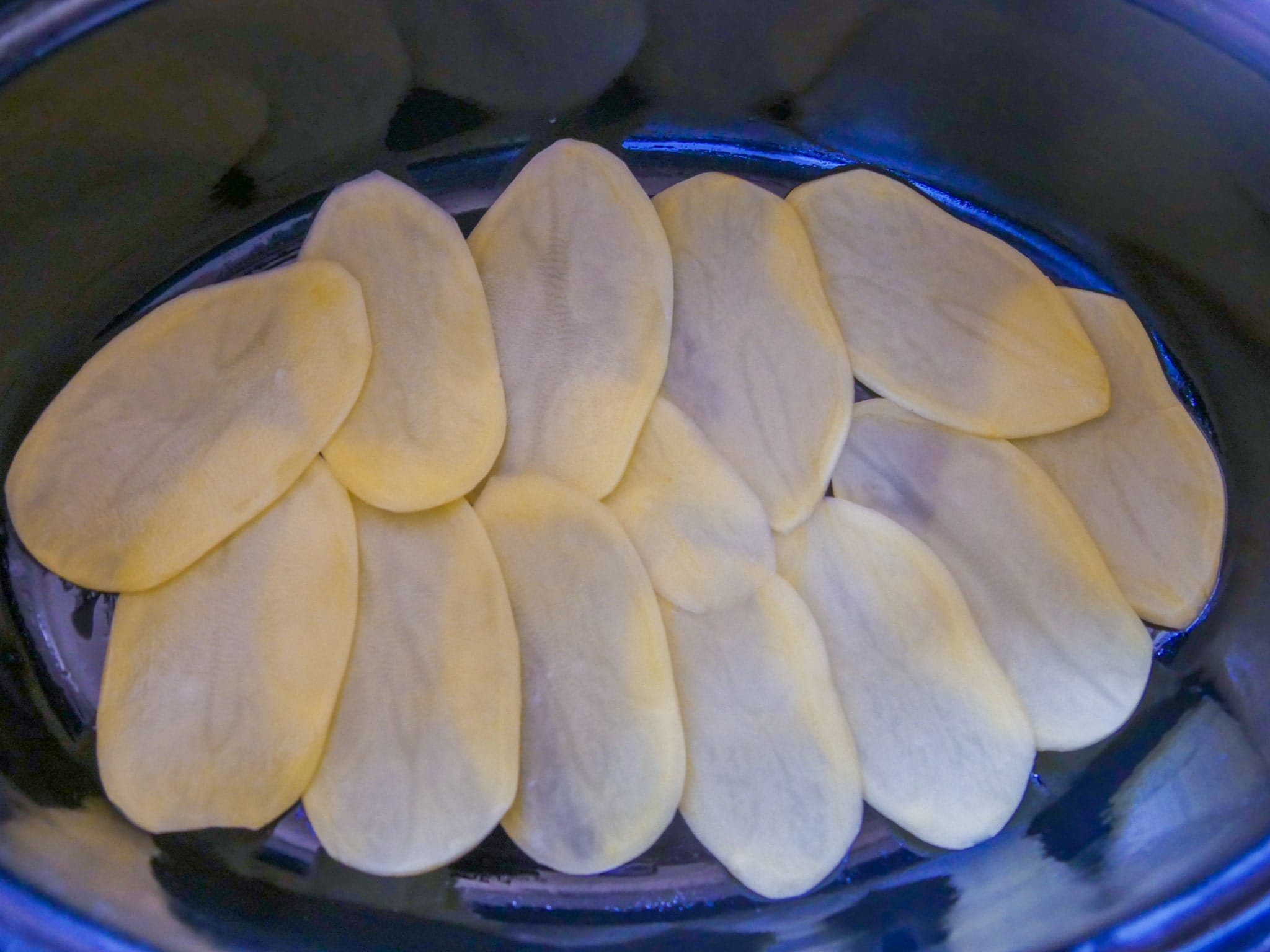 Gratinkartoffeln festkochend in Scheiben in die Auflaufform legen