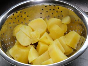 Kartoffeln für die Schupfnudeln abgießen