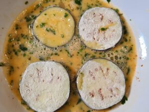 Mehlierte Aubergine in Ei mit Kräutern wenden