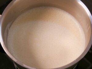 Milch, Zucker und Vanilleschote für Vanillesauce erwärmen