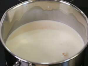 Milch und Sahne zum Zucker für Creme Brulee geben