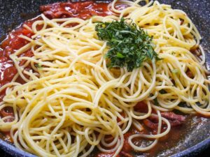 Nudeln und Petersilie zu Pasta Calabrese geben