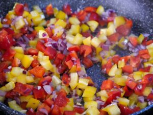 Paprika mit Zwiebeln anschwitzen für Kritharaki Salat