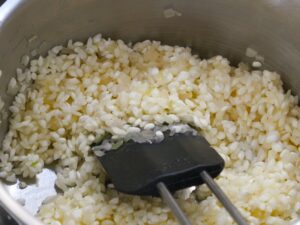 Risotto Reis mit den Schalottenwürfeln anschwitzen
