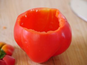 Rote Paprika kreisförmig einschneiden und Kernegehäuse entfernen
