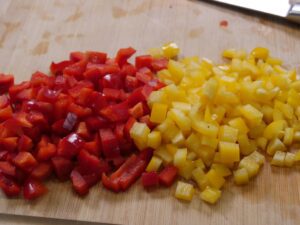 Rote und gelbe Paprika ind Würfel schneiden für Kritharaki Salat