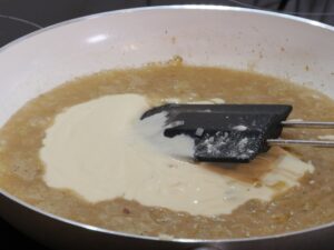 Saure Sahne zu der Sauce für Spargel-Lasagne geben