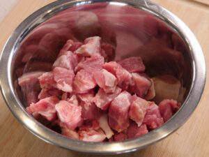 Schweinenacken in kleine gleichmäßige Stücke schneiden für Szegediner Gulasch