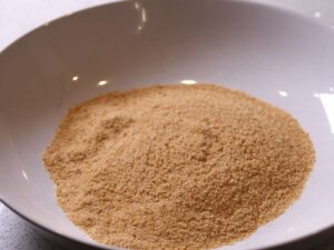 Semmelbrösel für ein knuspriges Schnitzel in einen tiefen Teller füllen