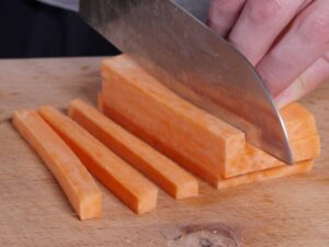 Süßkartoffel für Pommes in 8 mm dicke Stifte schneiden