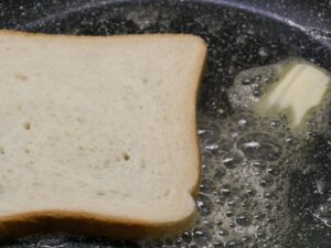 Toast oder Toastie für Egg Benedict in Pfanne mit etwas Butter anrösten