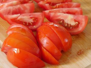 Tomate für griechischen Salat in Streifen schneiden