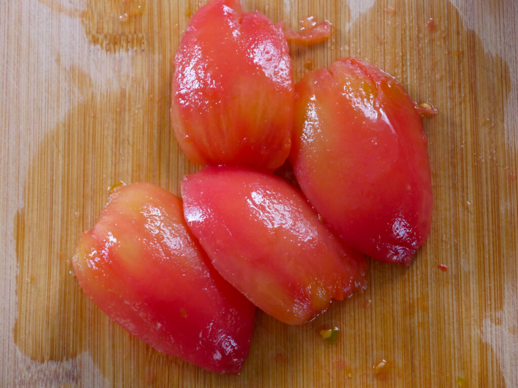 Tomate vierteln und entkernen und in feine Würfel schneiden