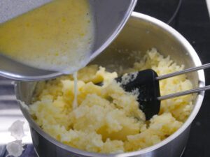 Warme Milch und Butter zu den Kartoffelflocken geben