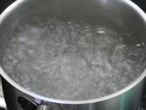 Wasser für poschiertes Ei zum Kochen bringen und dann Hitze herunterdrehen