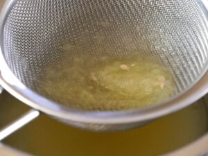 Zitronensaft für Sorbet durch ein Sieb geben