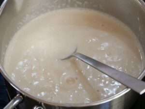 Zucker in Milch für Creme Brulee zum schmelzen bringen