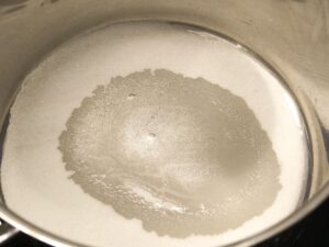 Zucker und Wasser in einen Topf geben und langsam erhitzen