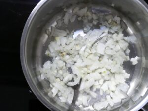 Zwiebeln und Knoblauch in Öl glasig anschwitzen für Zucchinipuffer