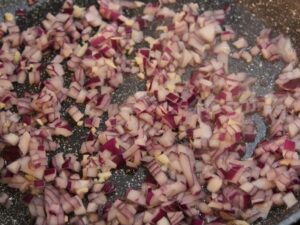 Zwiebeln und Knoblauch in Pfanne für Salat anschwitzen