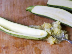 halbierte Zucchini zum füllen mit einem Löffel aushöhlen